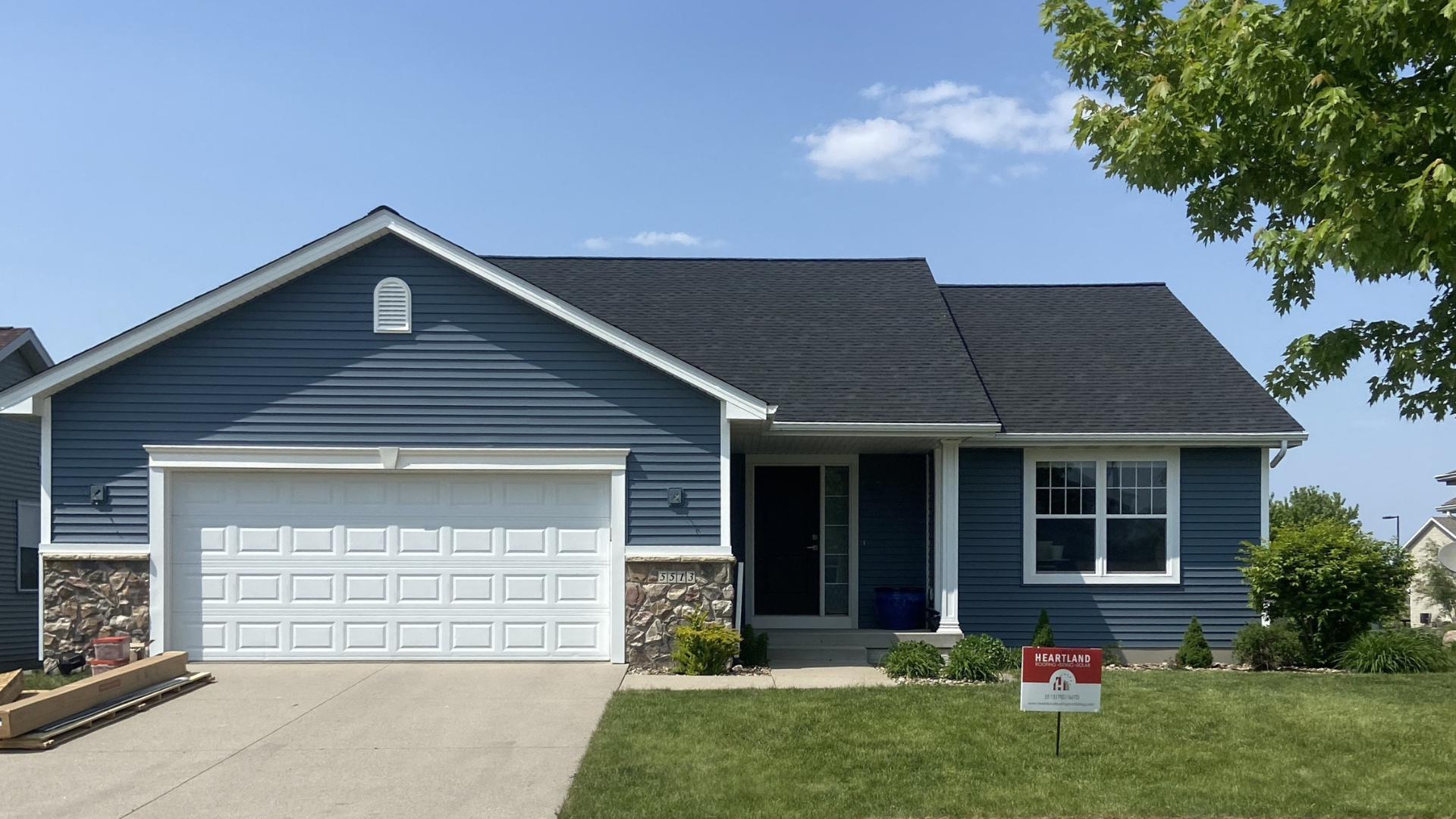 Single-story home with GAF Timberline HDZ SG shingles in Charcoal with Alside Coventry siding in Harbor Blue in Ames, Iowa.