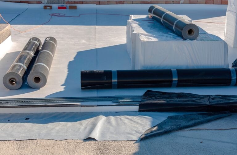 rolls of flat roof materials sitting on roof top of commercial building