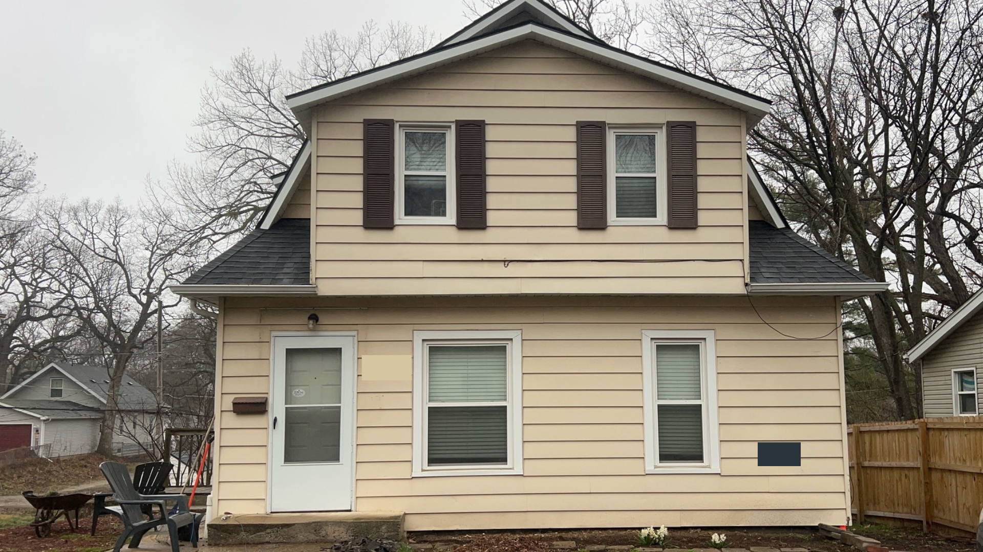 A house with yellow siding before a full siding replacement with new fascia. soffit, and wraps in Des Moines, Iowa.