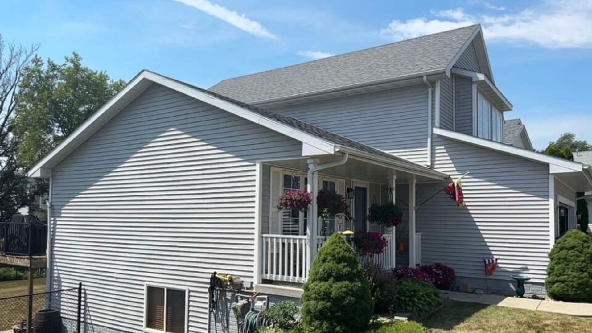 A Des Moines home with gray siding before a full siding replacement.