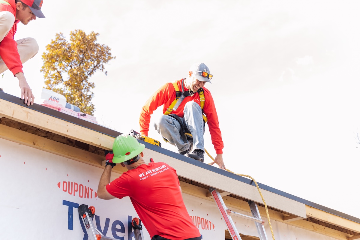 Heartland Roofing, Siding, and Solar team smiling and helping with roof giveaway in Winterset, Iowa.