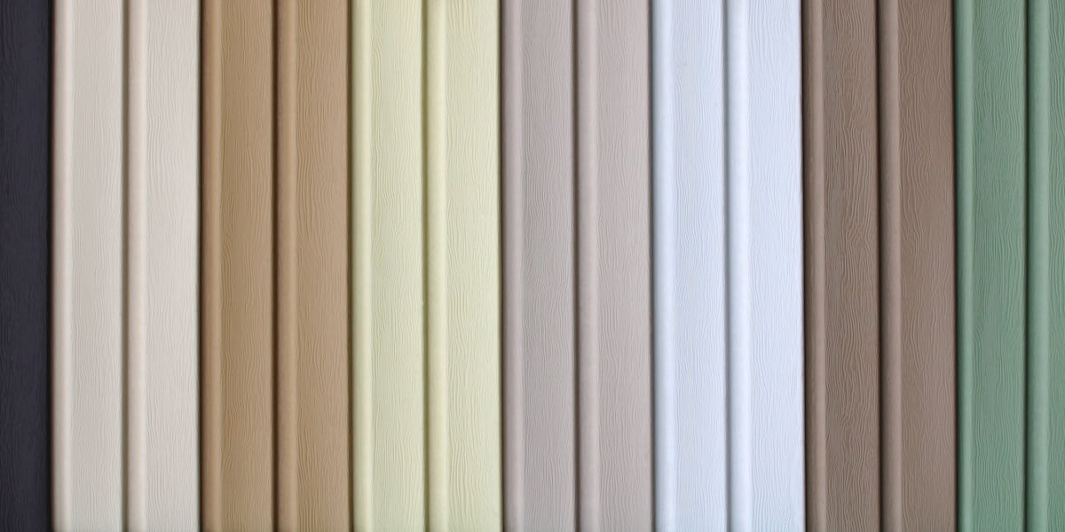 multicolored strips of vinyl siding samples for facing the walls of buildings as a background.